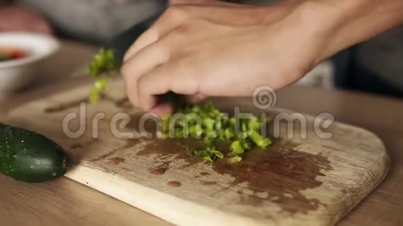 拍摄一个名叫穆拉托的年轻人切生菜做沙拉的慢镜头和他的女朋友共进午餐视频的预览图