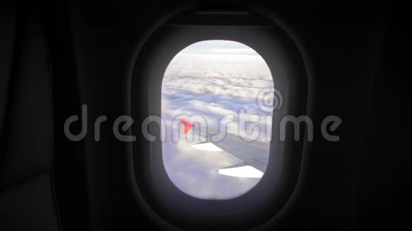 透过飞机的窗户观看蓝天和云彩带有飞机机翼的飞机窗口视频的预览图