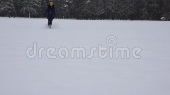女人跑过松雪的冬天户外空闲时间4K视频的预览图