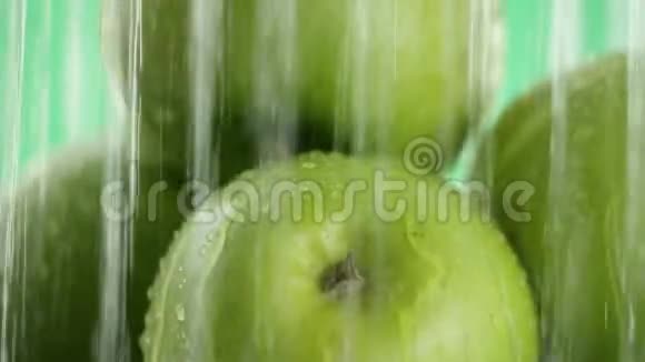 绿苹果水从不同喷流的顶部落下然后停下来绿色背景特写视频的预览图