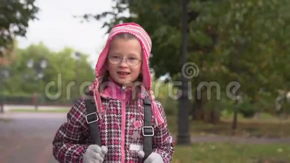 女孩在公园的人行道上散步一个女孩放学后在公园里散步视频的预览图