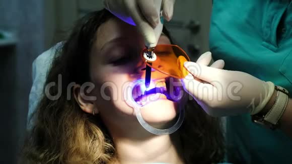 牙科助手用牙科聚合紫外线灯照射患者牙齿拜访口腔医生视频的预览图