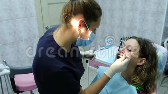 去看牙医一位医生正牙医生为一名口腔内有固定器的妇女安装了铁支架视频的预览图
