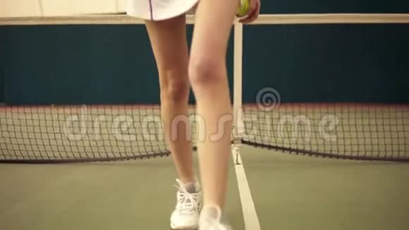 年轻的女网球运动员金发短发在镜头前行走动作缓慢球场覆盖视频的预览图