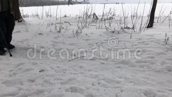 一个穿着毡靴的男子在积雪覆盖的人行道上行走视频的预览图