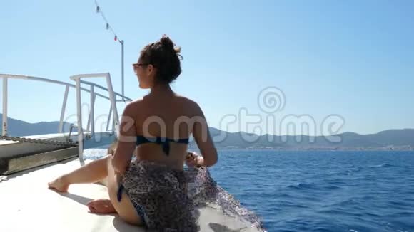 丰富的生活迷人的女孩放松在海滨度假胜地的游艇在夏季周末和织物挥动视频的预览图