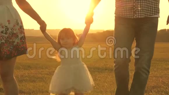 孩子们在夕阳下和爸爸妈妈在野外玩耍在大自然中和一个小孩子散步小女儿跳跳跳跳视频的预览图