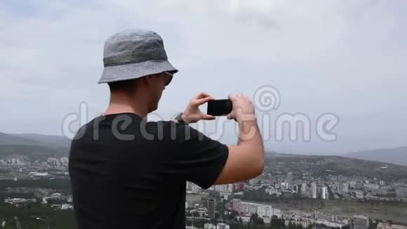 有城市景观的男人在电话里拍照视频的预览图