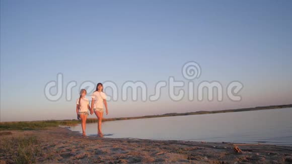 女孩青少年沿着海滩散步微笑视频的预览图