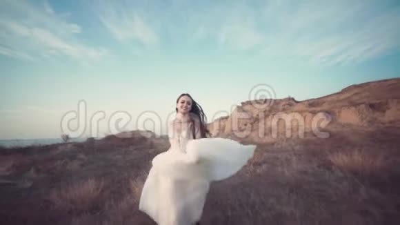 穿着漂亮的长裙子跑新娘穿过风景视频的预览图