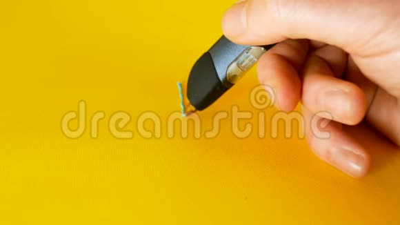 一个男人的手用一支3d打印笔在黄色背景上画出比特币的符号这是像视频的预览图