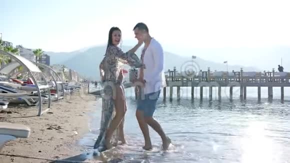 热情的舞蹈相爱的年轻夫妇在度假胜地的海滩上玩得开心视频的预览图