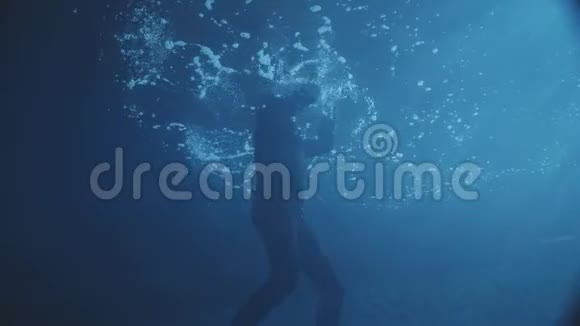 潜水者在黑暗的水里锻炼有一些灯光视频的预览图