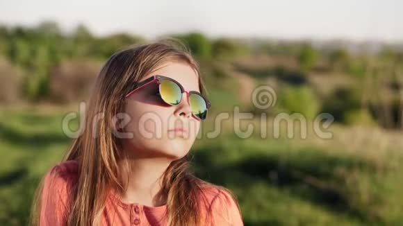 日落时戴太阳镜的女孩的肖像视频的预览图