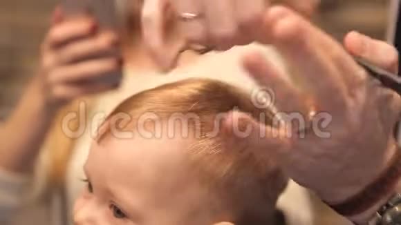 一个小孩在男理发师理发视频的预览图