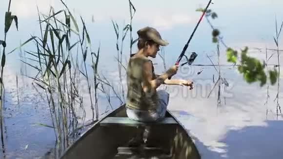 年轻女子渔夫正在森林湖上钓鱼拿着鱼竿扭动着线圈视频的预览图