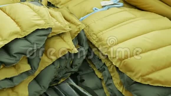 黄色的冬季夹克在服装厂的仓库里系在一起定制概念视频的预览图