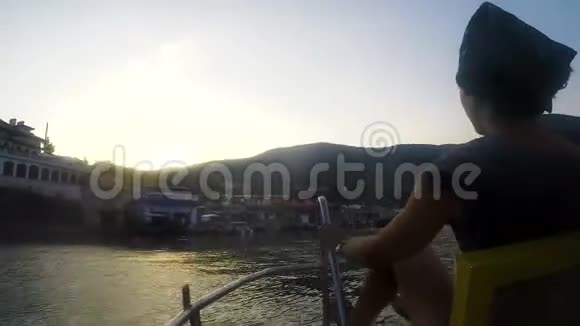 日落时分妇女乘坐双体船在度假小镇划船活跃的暑假视频的预览图