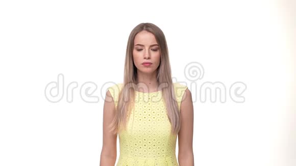一个年轻严肃的女人站在黄色背景下看着摄像机说不视频的预览图