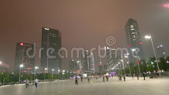 广州夜间时间推移摩天大楼在背景人们绕着这个地区的时间圈走视频的预览图