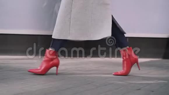 在秋天的街道上穿着红色靴子面目全非的女人的腿视频的预览图