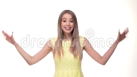 站在白色背景上的迷人女孩微笑着手举在镜头前视频的预览图
