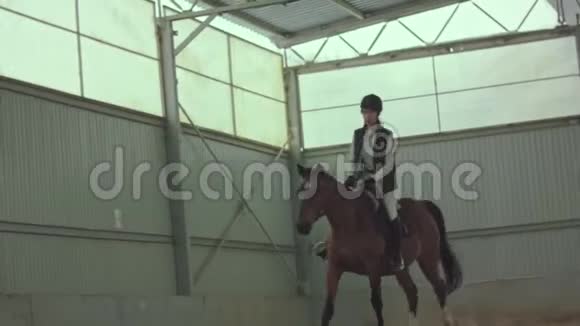 在室内围场周围骑马的女人视频的预览图