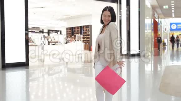 快乐的年轻女子在商场里拿着购物袋转悠视频的预览图