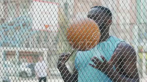被保释的黑人在监督下扔球在监狱里运动锻炼视频的预览图