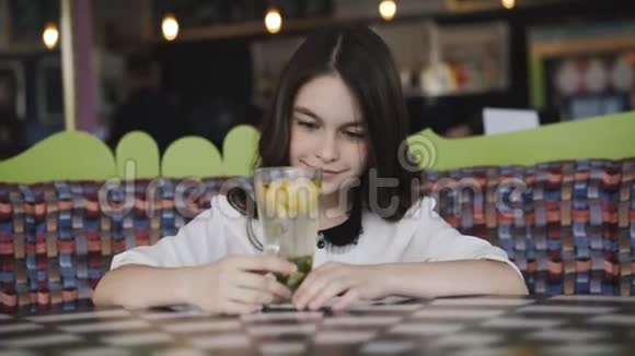 漂亮的女孩欣赏柠檬水在咖啡馆里服务4K视频的预览图