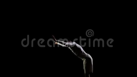在蹦床上的黑色背景上跳跃体操运动员自由和飞行视频的预览图