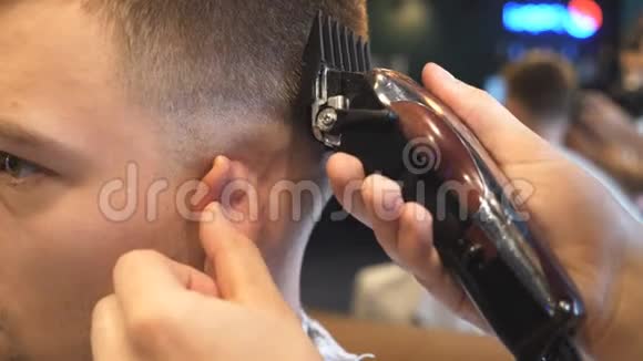 在沙龙里用剪头刀把理发师的手臂拢到顾客面前发型师剪头发的手视频的预览图
