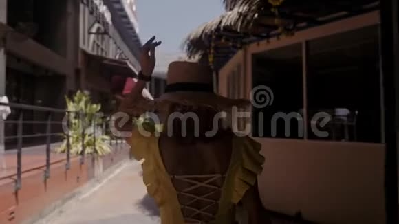 戴草帽的漂亮女人走在街上对着镜头玩视频的预览图