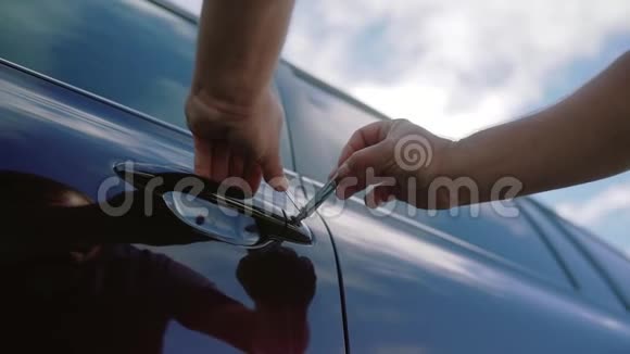 男机修工或小偷手持撬锁器打开车门关门视频的预览图