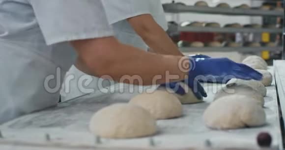 在商业面包业中专业的面包师用面团制作面包片视频的预览图