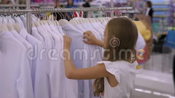 在服装店里挑选白色衬衫的少女时尚和购物视频的预览图