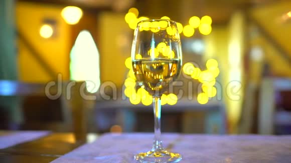 在假日波克闪烁背景餐厅的玻璃中的白葡萄酒录像一杯白葡萄酒概念视频的预览图