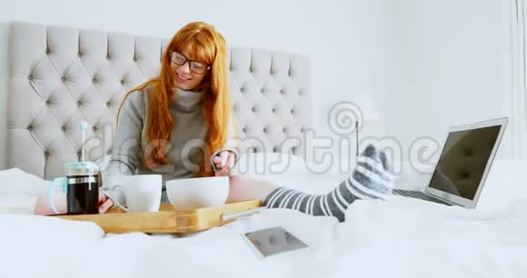 美丽的女人在床上煮咖啡视频的预览图