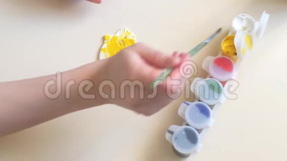 女孩的手粉刷石膏图形的颜色特写我们用水彩和颜料画画视频的预览图