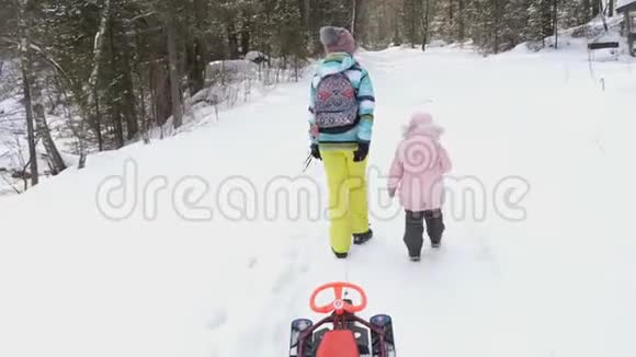 女人和孩子一起走在冬天的森林里视频的预览图