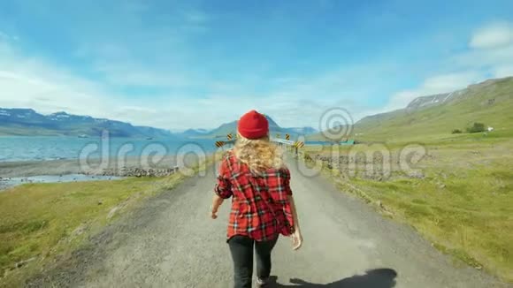 嬉皮士女人走在空旷的史诗路上视频的预览图