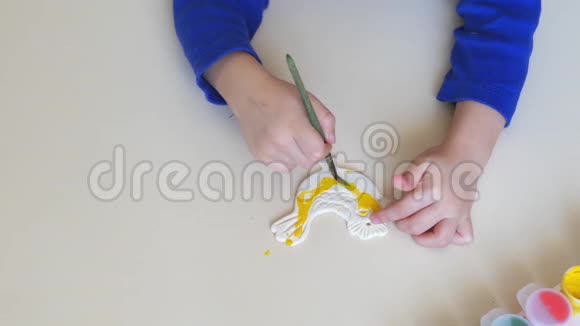 孩子手把石膏图形的颜色涂成特写用水彩和颜料画画儿童发展视频的预览图