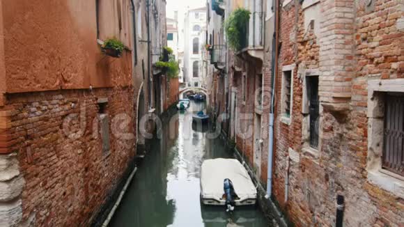 威尼斯狭窄街道上的一条水渠停泊的船只视频的预览图