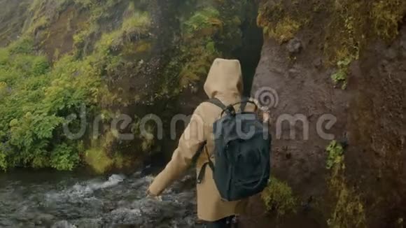 年轻的旅行博客写手带瀑布的史诗洞视频的预览图
