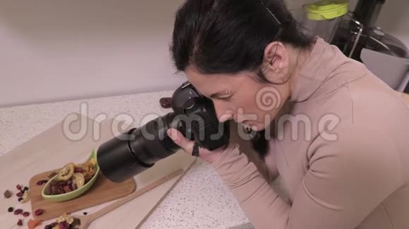 女摄影师配有近厨房食物成分的专业相机视频的预览图