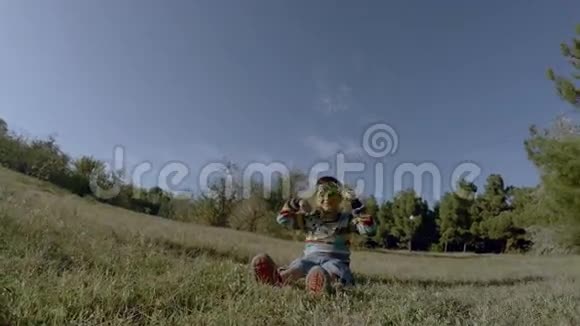 男孩坐在草地上玩耍视频的预览图
