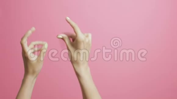 一个年轻女人的手在粉红色的画室背景上欢快地拍打着节拍视频的预览图