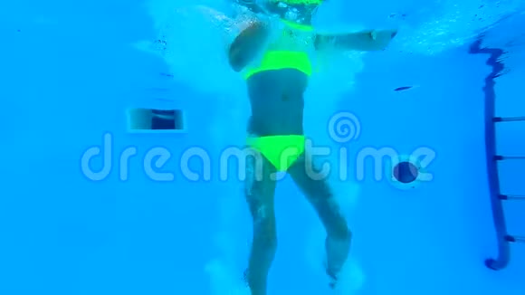 女孩在游泳池的水下潜水竖起大拇指视频的预览图