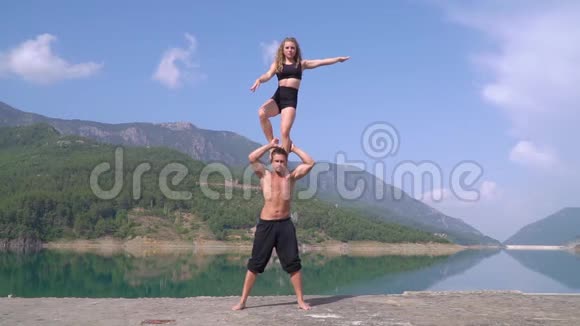 阿拉尼亚美丽海湾背景下的体操运动员在表演前接受训练视频的预览图