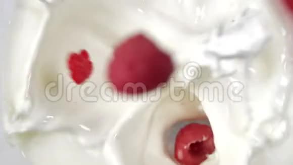 顶部观看慢动作新鲜多汁浆果落入白色牛奶或酸奶特写视频的预览图